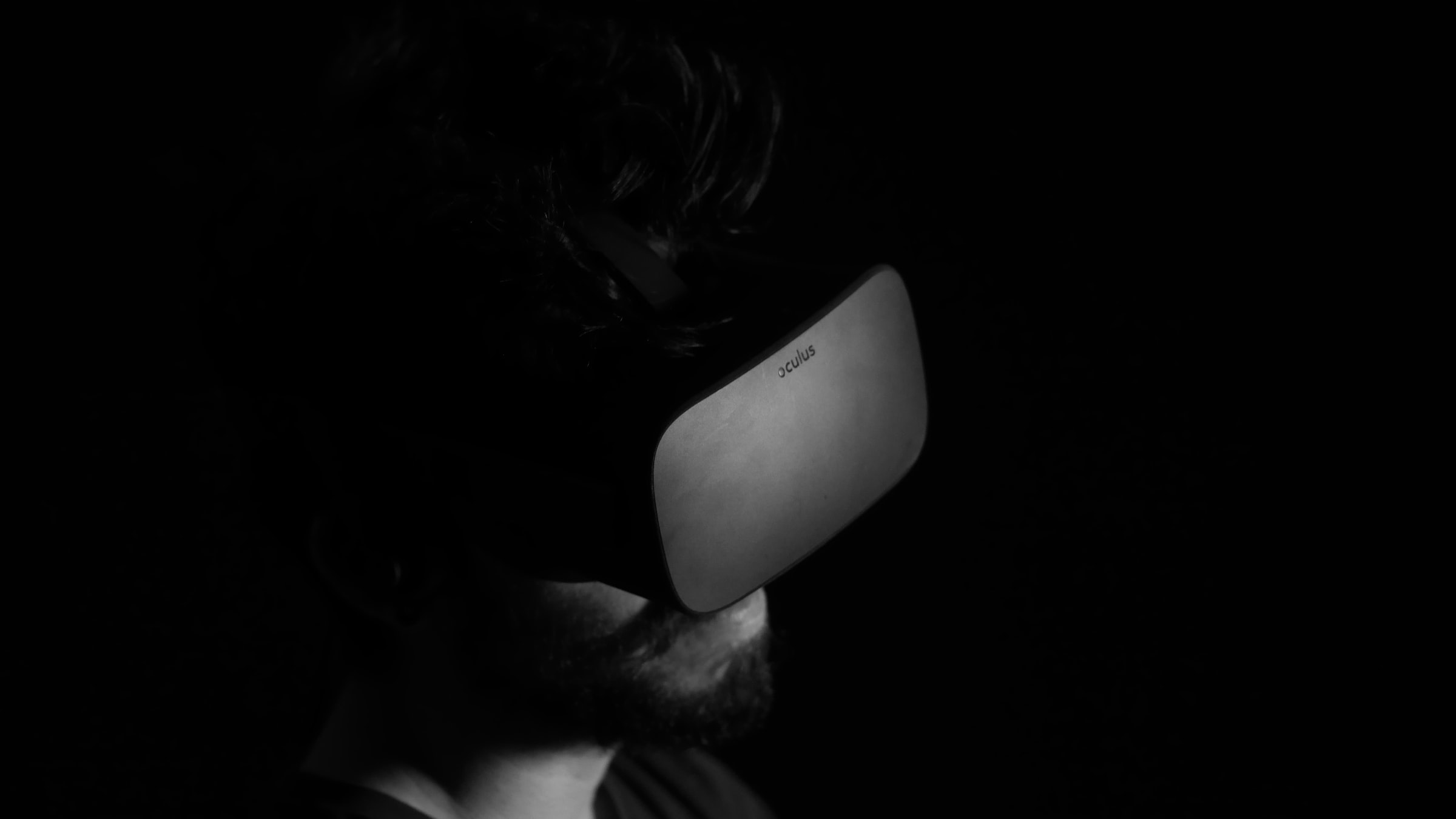 A man wearing a VR headset in the dark.